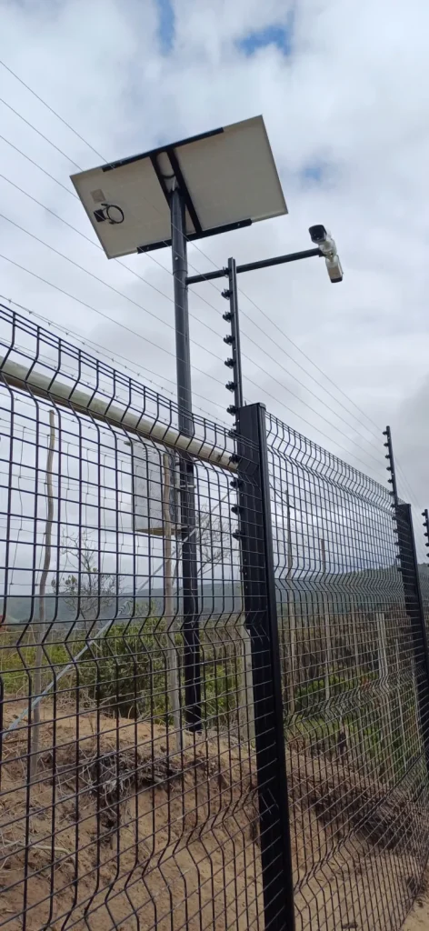 Electric fence brackets on a clearview fence with a solar-powered CCTV camera pole, coastal estate, Plettenberg Bay