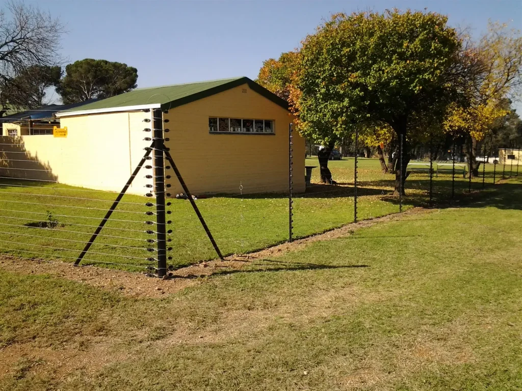 Freestanding electric fence around an outbuilding on a smallholding lawn