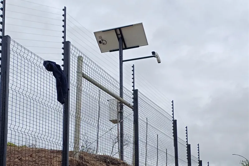Solar camera pole on a freestanding fence